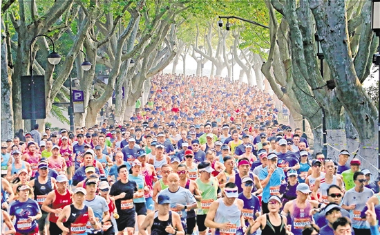 参赛选手从西湖景区北山街跑过。